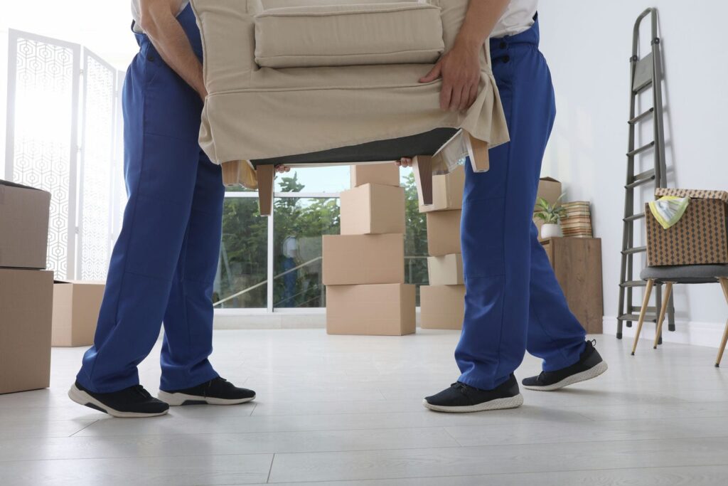 movers carrying couch in living room